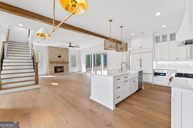 1031 Longview Commons, Greensboro, GA 30642 - kitchen with appliances with stainless steel finishes, custom exhaust hood, a ceiling fan, a stone fireplace, and recessed lighting