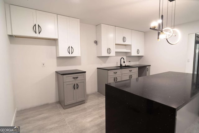 69 N Hearn Rd, Ellenwood, GA 30294 - kitchen with a kitchen island, white cabinetry, decorative light fixtures, and dark stone countertops