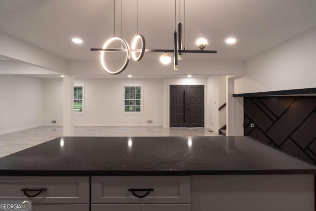 69 N Hearn Rd, Ellenwood, GA 30294 - kitchen with open floor plan, dark stone countertops, recessed lighting, gray cabinets, and wood finished floors