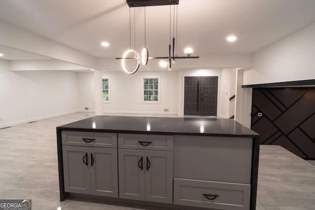 69 N Hearn Rd, Ellenwood, GA 30294 - kitchen with open floor plan, dark countertops, gray cabinetry, a kitchen island, and a chandelier