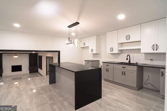 69 N Hearn Rd, Ellenwood, GA 30294 - kitchen with dark countertops, decorative light fixtures, white cabinetry, a center island, and light tile patterned floors