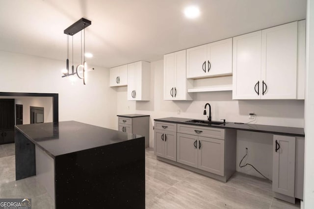 69 N Hearn Rd, Ellenwood, GA 30294 - kitchen with dark countertops, a center island, pendant lighting, and white cabinetry