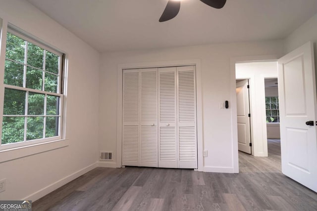 69 N Hearn Rd, Ellenwood, GA 30294 - unfurnished bedroom featuring wood finished floors, multiple windows, a closet, and ceiling fan