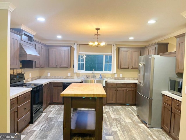175 Bob White St, Jesup, GA 31545 - kitchen with stainless steel appliances, butcher block countertops, light wood-style floors, premium range hood, and crown molding