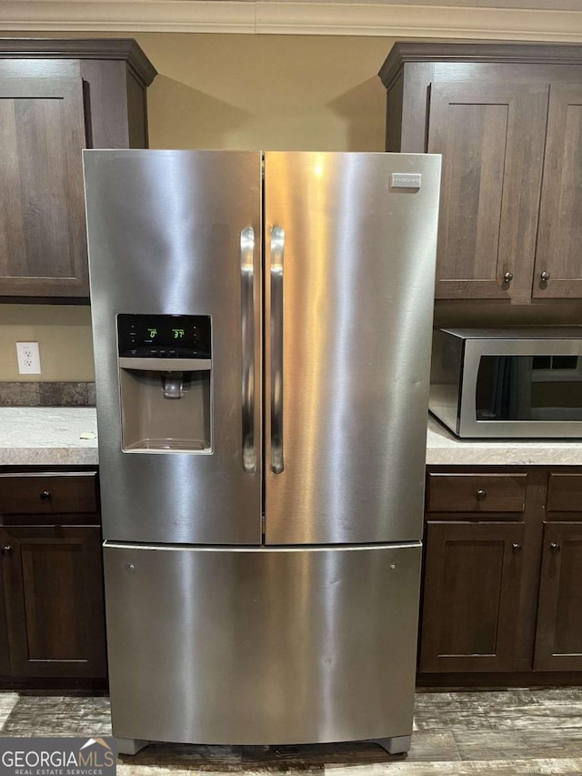 175 Bob White St, Jesup, GA 31545 - kitchen view of stainless steel appliances, dark brown cabinetry, light wood finished floors, light countertops, and ornamental molding