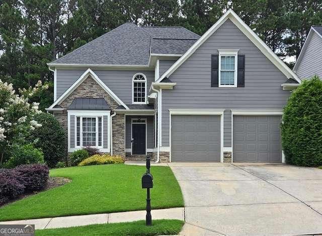595 Bentleaf Dr, Dallas, GA 30132 - traditional-style home with stone siding, concrete driveway, an attached garage, a front yard, and roof with shingles