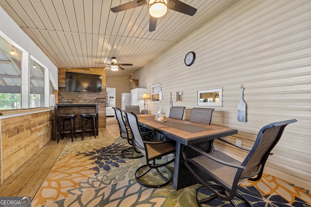 321 Barbara Point Rd, Sparta, GA 31087 - dining room featuring a ceiling fan, wood walls, and vaulted ceiling