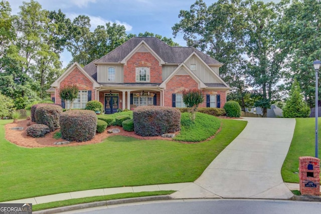 3217 Aberrone Pl, Buford, GA 30519 - view of front of house featuring brick siding, board and batten siding, a front yard, and concrete driveway