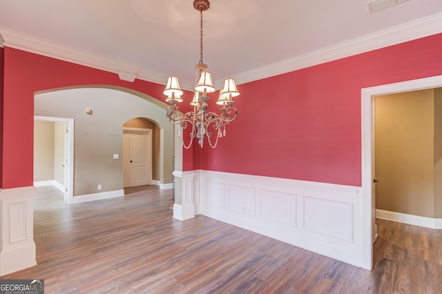 3217 Aberrone Pl, Buford, GA 30519 - empty room featuring arched walkways, wood finished floors, a chandelier, and crown molding