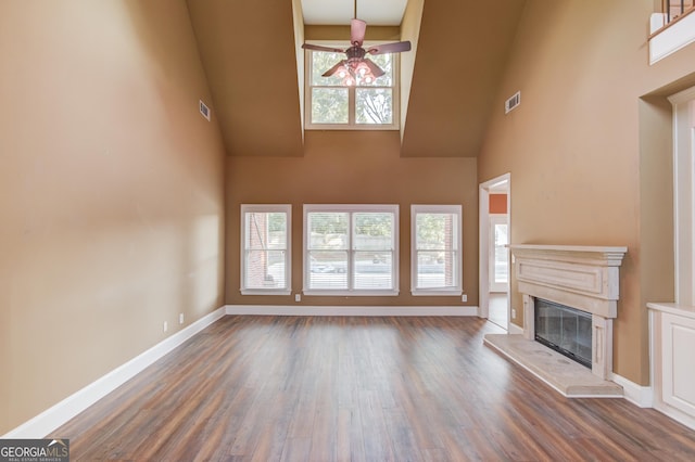 3217 Aberrone Pl, Buford, GA 30519 - unfurnished living room featuring high vaulted ceiling, a ceiling fan, wood finished floors, and a glass covered fireplace
