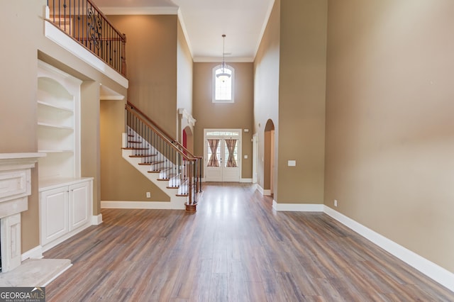 3217 Aberrone Pl, Buford, GA 30519 - entryway featuring stairs, arched walkways, wood finished floors, a high ceiling, and ornamental molding