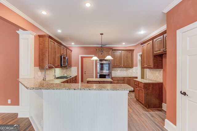 3217 Aberrone Pl, Buford, GA 30519 - kitchen featuring appliances with stainless steel finishes, a peninsula, light stone counters, light wood-type flooring, and tasteful backsplash