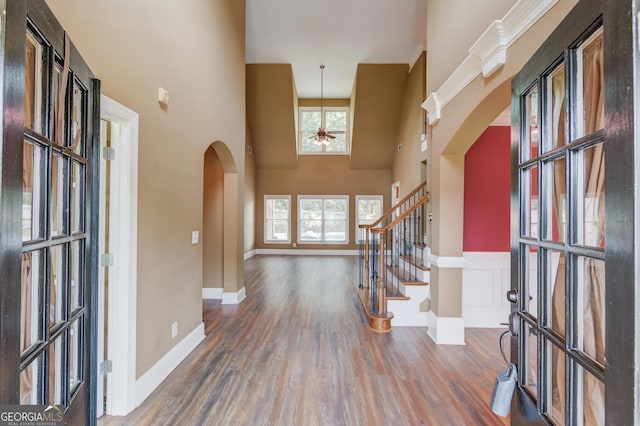 3217 Aberrone Pl, Buford, GA 30519 - foyer featuring arched walkways, wood finished floors, ceiling fan, a towering ceiling, and stairs