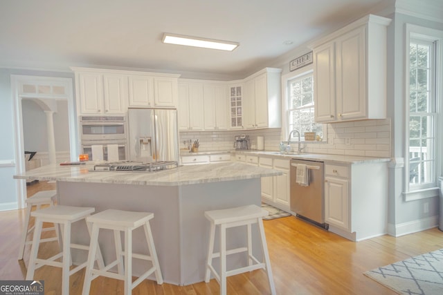 361 Fairway Cir, Monroe, GA 30656 - kitchen featuring stainless steel appliances, decorative backsplash, a kitchen bar, and a kitchen island