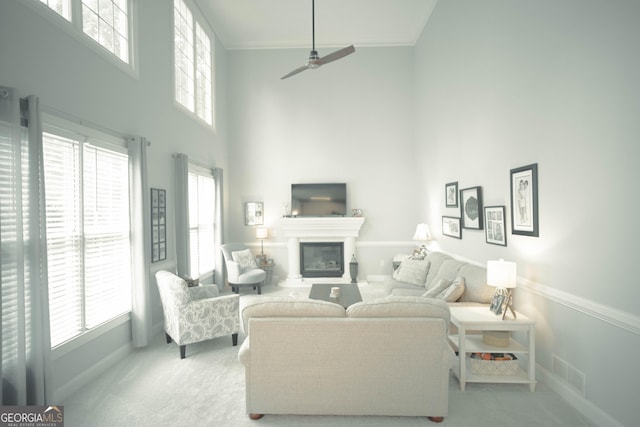 361 Fairway Cir, Monroe, GA 30656 - carpeted living area with a high ceiling, healthy amount of natural light, ceiling fan, a glass covered fireplace, and crown molding