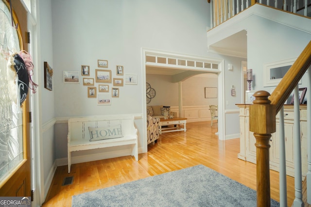 361 Fairway Cir, Monroe, GA 30656 - entryway with arched walkways, wood finished floors, stairway, a high ceiling, and crown molding
