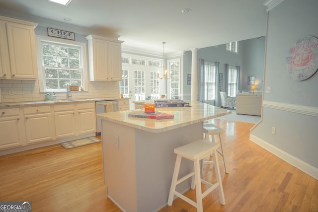 361 Fairway Cir, Monroe, GA 30656 - kitchen featuring stainless steel dishwasher, a kitchen island, white cabinets, a kitchen bar, and healthy amount of natural light