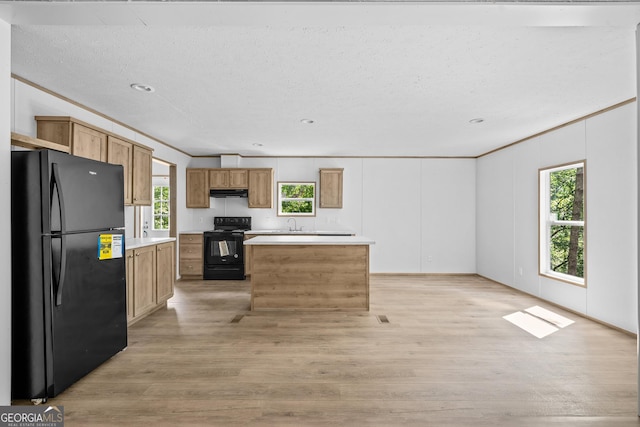 134 Double Line Rd, Ellijay, GA 30540 - kitchen featuring black appliances, under cabinet range hood, light countertops, light wood-style flooring, and a center island