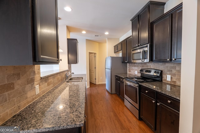 3511 Brockenhurst Dr, Buford, GA 30519 - kitchen featuring stainless steel appliances, decorative backsplash, wood finished floors, dark brown cabinetry, and recessed lighting