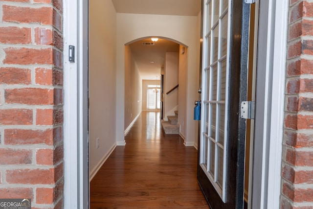 3511 Brockenhurst Dr, Buford, GA 30519 - hallway with arched walkways, dark wood finished floors, and stairway