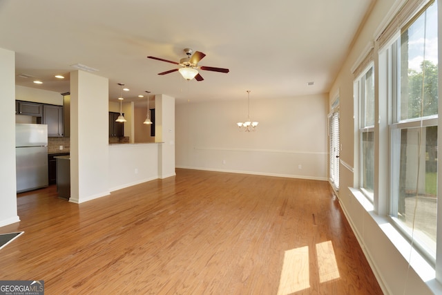 3511 Brockenhurst Dr, Buford, GA 30519 - unfurnished living room with a chandelier, light wood finished floors, and a ceiling fan