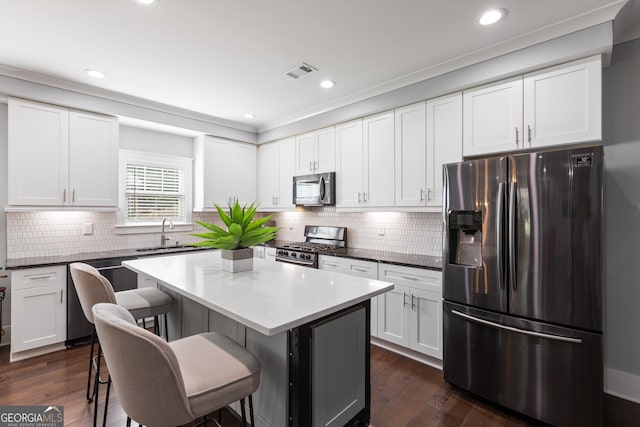 1967 Cogar Dr, Decatur, GA 30032 - kitchen with stainless steel appliances, a breakfast bar area, a center island, white cabinets, and recessed lighting