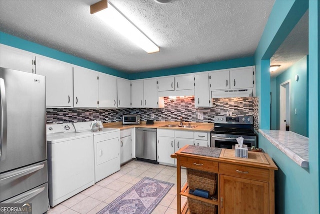 1777 Cedar Shoals Dr Unit 1775, Athens, GA 30605 - kitchen featuring appliances with stainless steel finishes, washer and dryer, under cabinet range hood, decorative backsplash, and light countertops