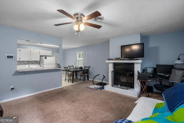 1777 Cedar Shoals Dr Unit 1775, Athens, GA 30605 - living room with a ceiling fan, washer / dryer, a brick fireplace, a textured ceiling, and light colored carpet