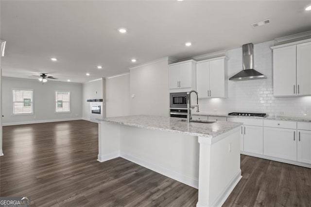 3382 Monarch Ave, Duluth, GA 30096 - kitchen with wall chimney range hood, appliances with stainless steel finishes, a kitchen island with sink, backsplash, and white cabinets