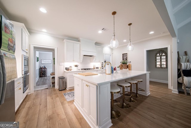 96 Cypress Trl, Fortson, GA 31808 - kitchen with appliances with stainless steel finishes, crown molding, white cabinets, a breakfast bar area, and recessed lighting