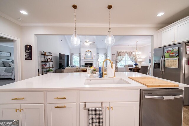 96 Cypress Trl, Fortson, GA 31808 - kitchen featuring appliances with stainless steel finishes, a fireplace, open floor plan, ornamental molding, and white cabinetry