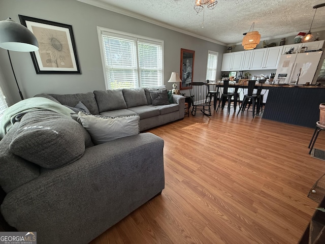 604 Spencer St, Barnesville, GA 30204 - living room with ornamental molding, light wood-style flooring, and a textured ceiling