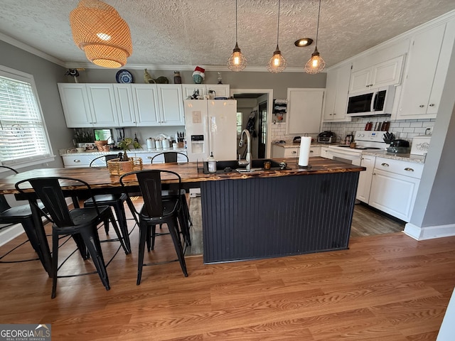 604 Spencer St, Barnesville, GA 30204 - kitchen featuring white appliances, a textured ceiling, white cabinets, crown molding, and backsplash