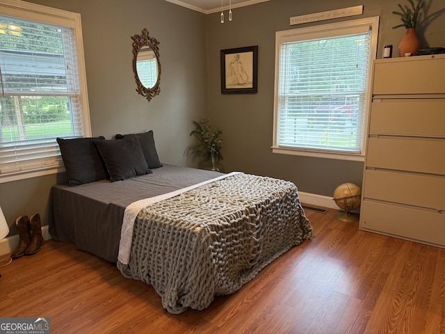 604 Spencer St, Barnesville, GA 30204 - bedroom featuring light wood-type flooring, multiple windows, and crown molding