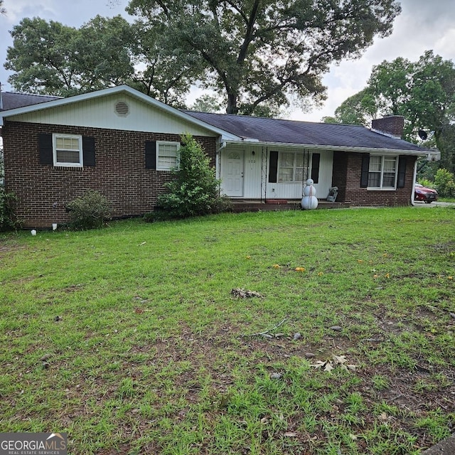 102 Shelia Dr, Warner Robins, GA 31088 - single story home featuring brick siding, a chimney, and a front yard