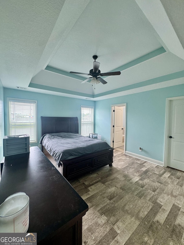 139 Raymond Cir, Warner Robins, GA 31088 - bedroom with a raised ceiling, multiple windows, wood finished floors, a ceiling fan, and a textured ceiling