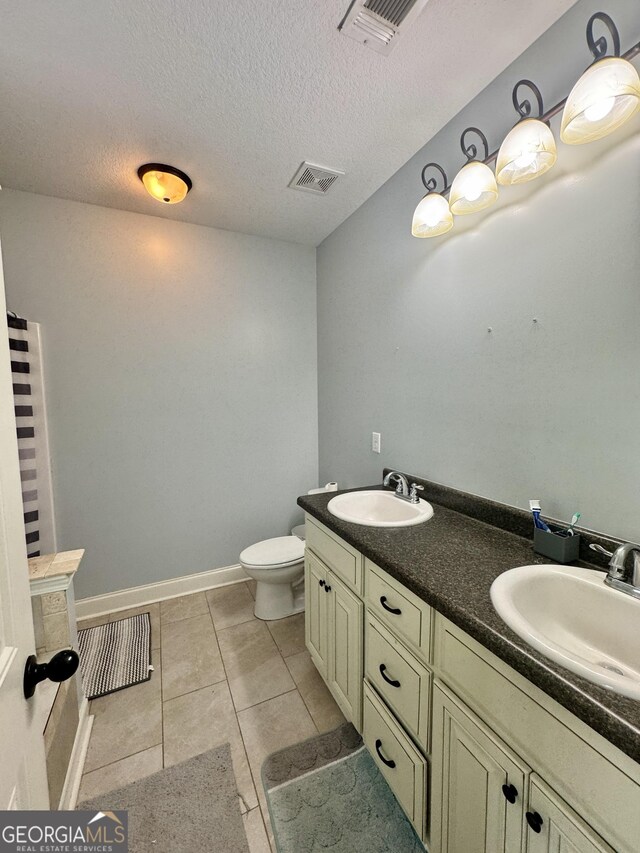 139 Raymond Cir, Warner Robins, GA 31088 - bathroom with a textured ceiling, double vanity, and tile patterned floors