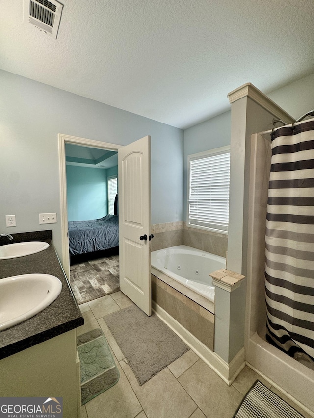 139 Raymond Cir, Warner Robins, GA 31088 - ensuite bathroom featuring a tub with jets, tile patterned flooring, curtained shower, double vanity, and a textured ceiling