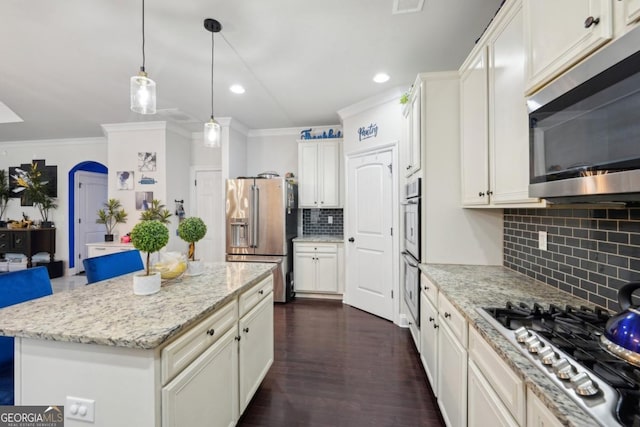 3225 Alhambra Cir, Hampton, GA 30228 - kitchen featuring stainless steel appliances, decorative backsplash, ornamental molding, light stone counters, and decorative light fixtures