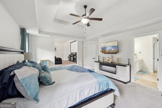 3225 Alhambra Cir, Hampton, GA 30228 - bedroom featuring a raised ceiling, light colored carpet, ensuite bath, and a ceiling fan