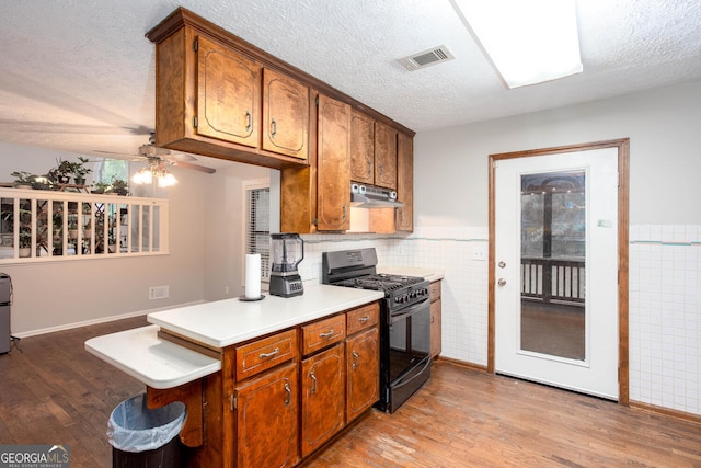 3470 Hill Ln, Acworth, GA 30102 - kitchen featuring gas stove, under cabinet range hood, light wood-type flooring, a textured ceiling, and ceiling fan
