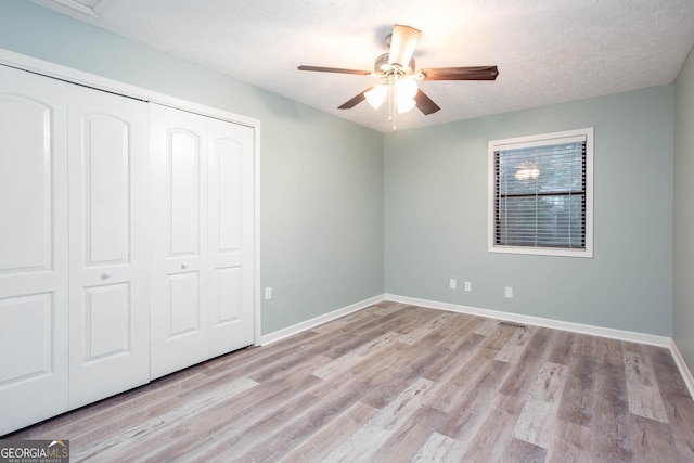3470 Hill Ln, Acworth, GA 30102 - unfurnished bedroom featuring a closet, wood finished floors, a ceiling fan, and a textured ceiling
