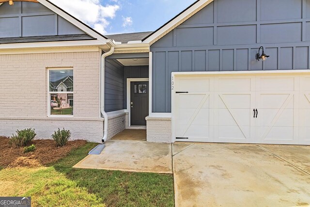 225 Rusty Plow Ln Unit 72, Perry, GA 31069 - view of front of property with board and batten siding, brick siding, driveway, and an attached garage