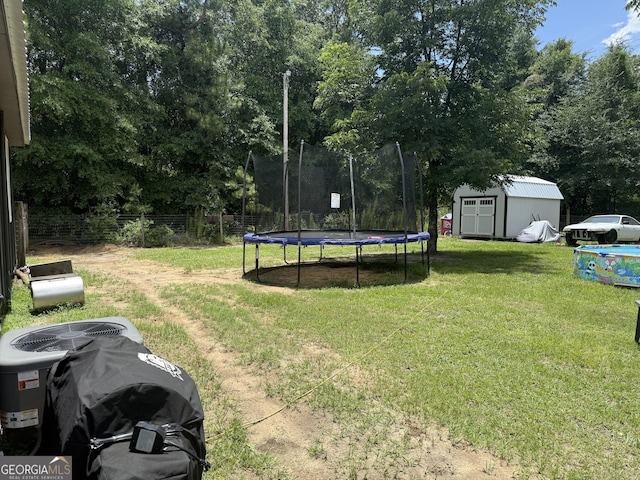 3052 Effingham Hwy, Sylvania, GA 30467 - view of yard featuring a trampoline, a storage unit, and view of wooded area