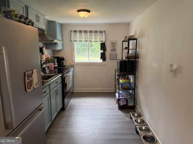 3052 Effingham Hwy, Sylvania, GA 30467 - kitchen with stainless steel appliances, wood finished floors, and wall chimney range hood