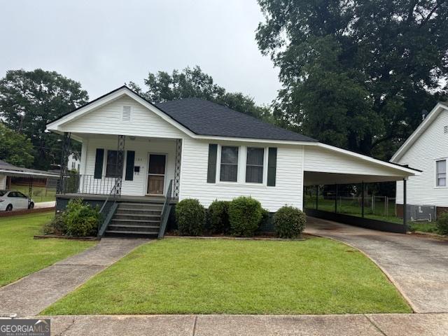 163 NW R St, Thomaston, GA 30286 - view of front of property featuring a porch, a front yard, driveway, and a carport