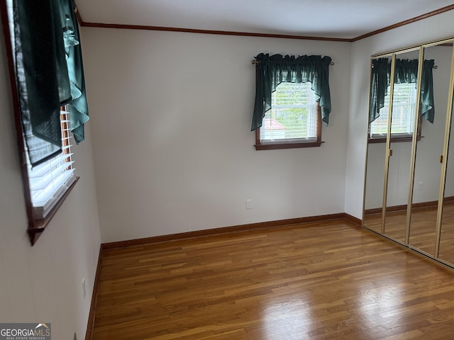 163 NW R St, Thomaston, GA 30286 - unfurnished bedroom with crown molding, wood finished floors, and a closet