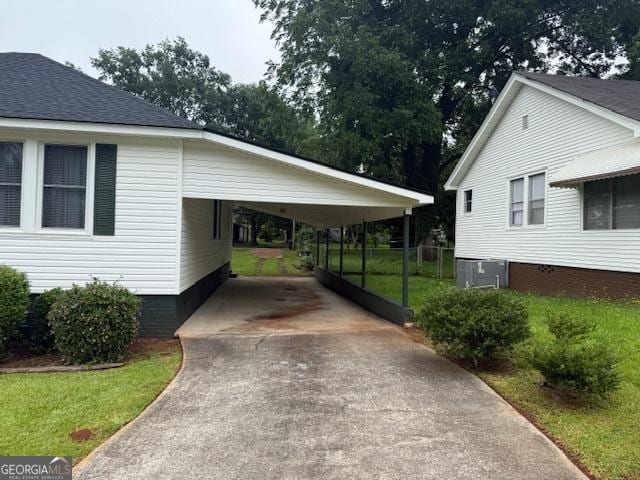 163 NW R St, Thomaston, GA 30286 - view of parking with concrete driveway and a carport