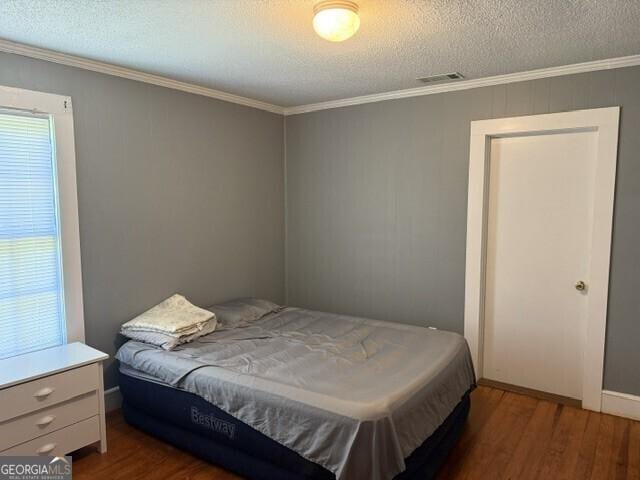 502 S Hull St, Sylvania, GA 30467 - bedroom with ornamental molding, wood finished floors, and a textured ceiling