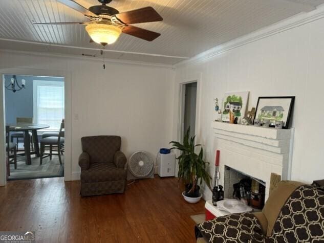 502 S Hull St, Sylvania, GA 30467 - living area featuring wood finished floors, a ceiling fan, crown molding, a fireplace, and a chandelier